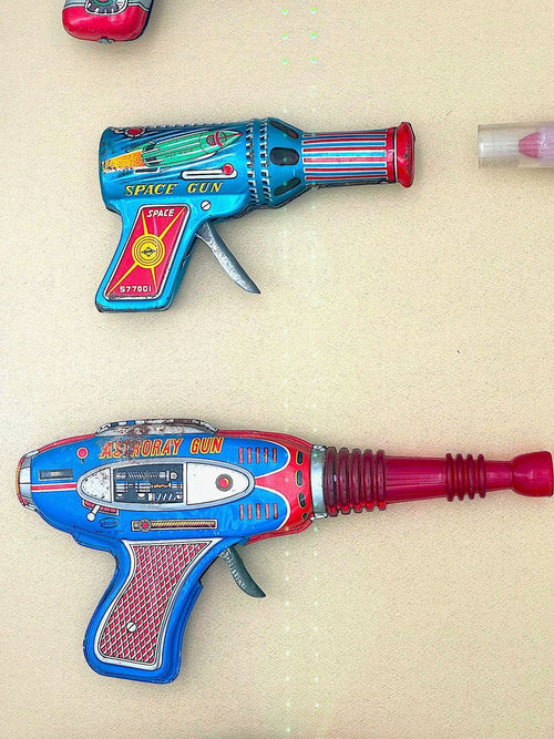 Mid century tinplate and plastic ray guns mounted in a white box frame