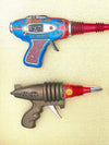 Mid century tinplate and plastic ray guns mounted in a white box frame