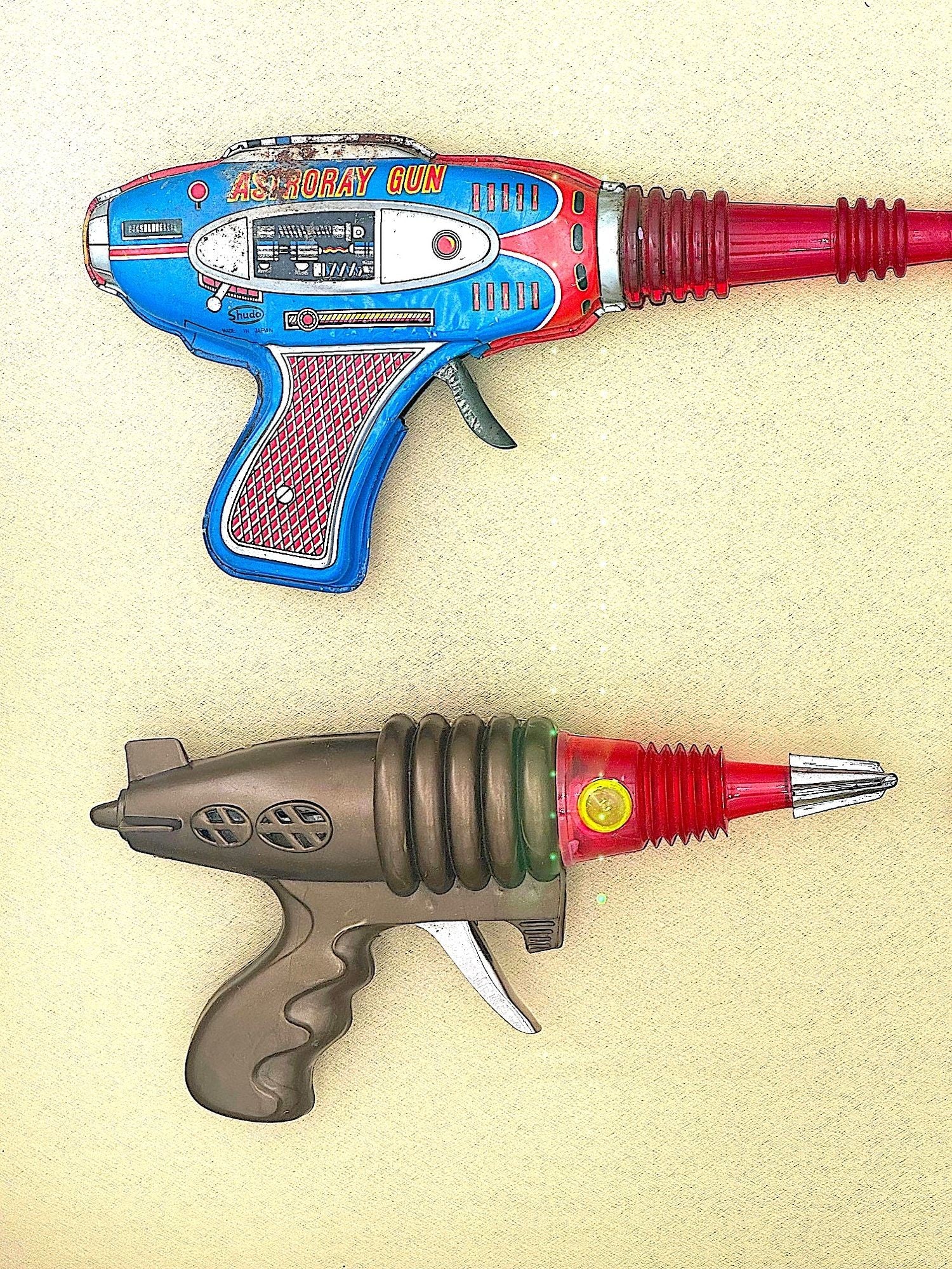 First Plastic Gun A collection of 1960s/70s tinplate and plastic ray guns mounted in a w ...