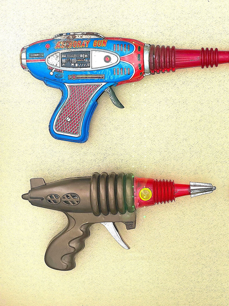 Mid century tinplate and plastic ray guns mounted in a white box frame