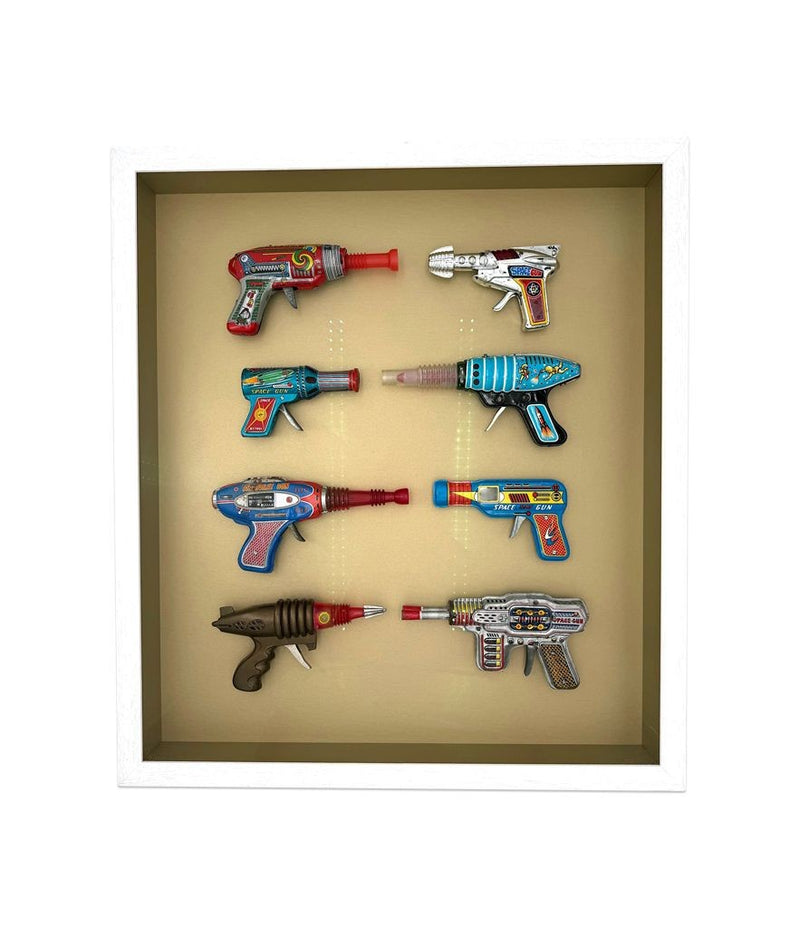 Mid century tinplate and plastic ray guns mounted in a white box frame
