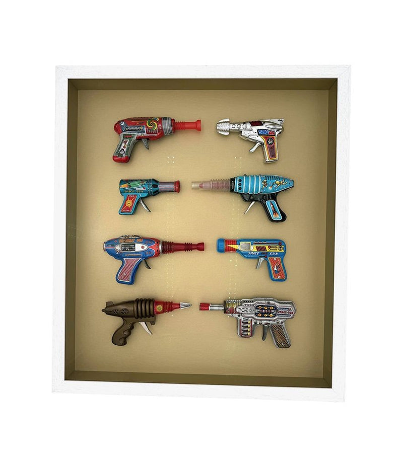 Mid century tinplate and plastic ray guns mounted in a white box frame