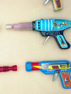 Mid century tinplate and plastic ray guns mounted in a white box frame