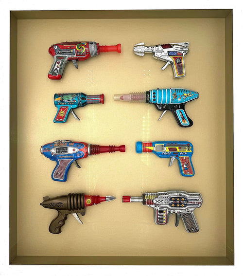 Mid century tinplate and plastic ray guns mounted in a white box frame