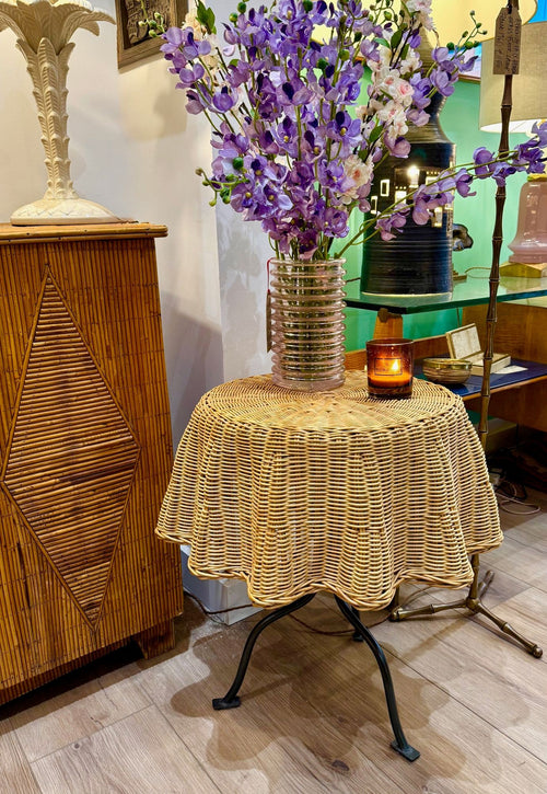 An Italian 1970s woven rattan "draped" side table with cost iron legs