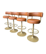 A set of four Börje Johanson “Jupiter” bar stools in cognac faux leather