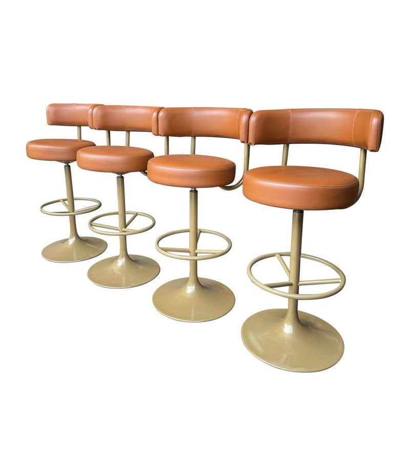 A set of four Börje Johanson “Jupiter” bar stools in cognac faux leather
