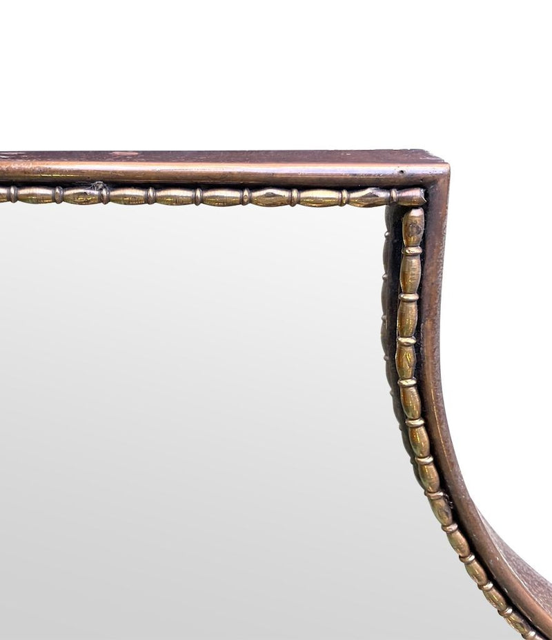 An orignal Italian 1960s brass shield mirror with beaded inner frame detail
