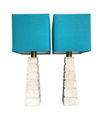 Mid Century table lamps with Travertine bases and brass fittings with blue linen shades