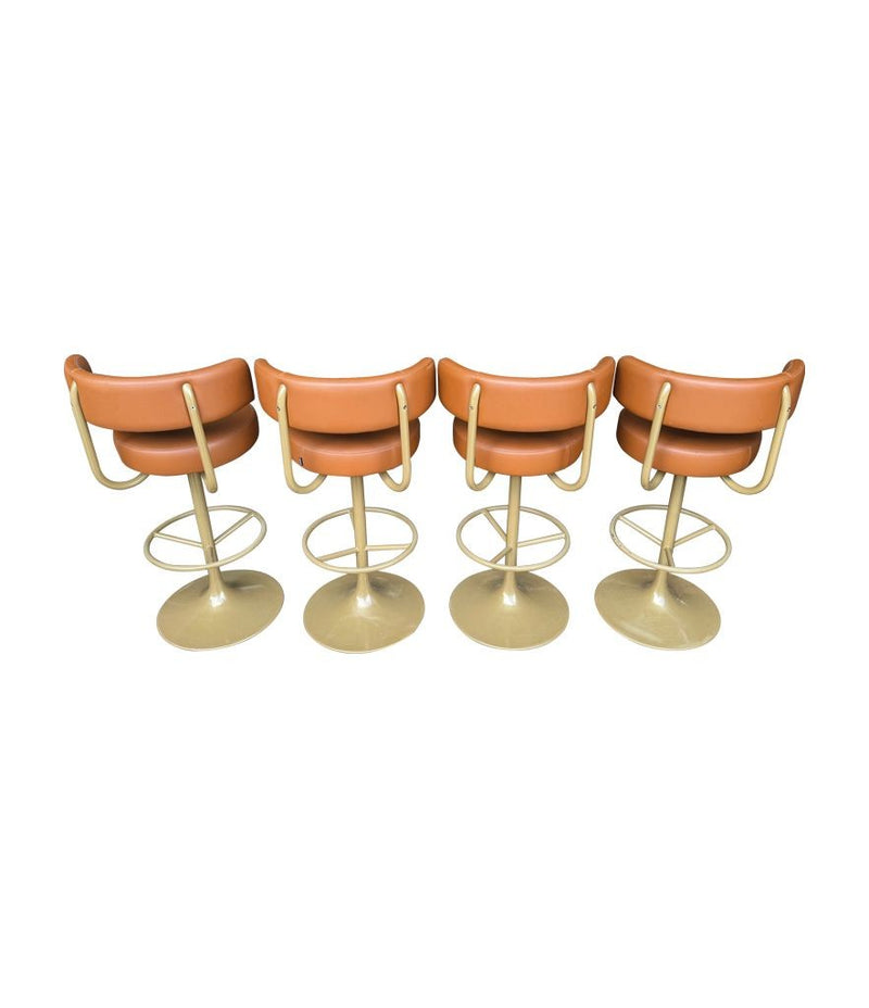 A set of four Börje Johanson “Jupiter” bar stools in cognac faux leather