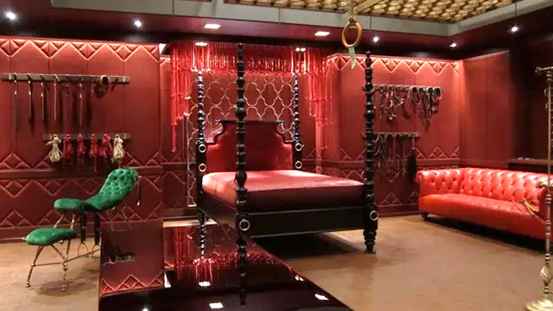 Image of the red room fron the 50 shades of Grey film with a green Tally Ho Chair in it