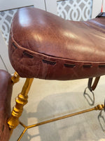 A Mark Brazier Jones "Tally Ho" chair a sculptural chair upholstered in a tan leather, with leather reigns, straps and steel stirrups on a stylised gilt wrought iron frame