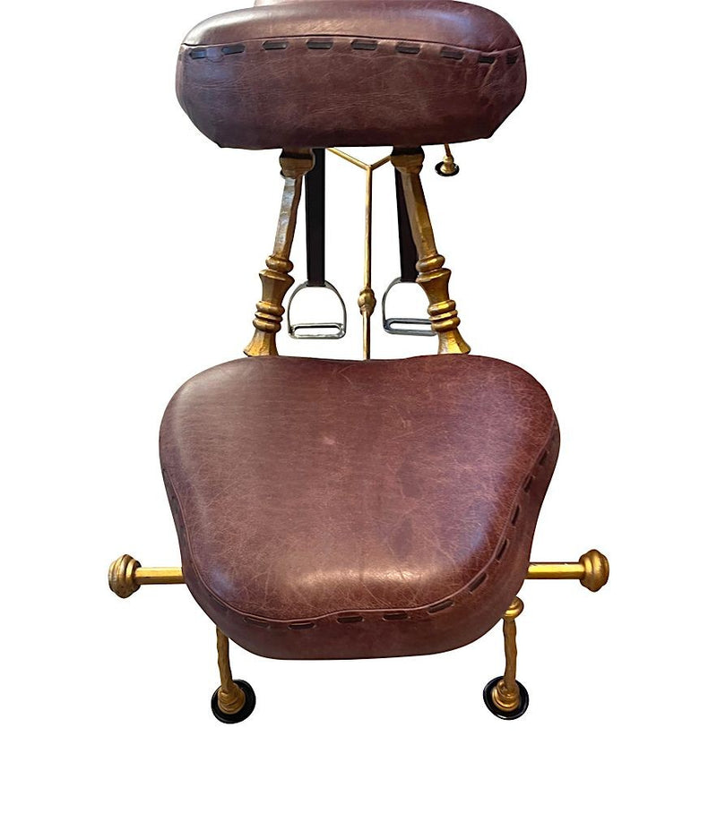 A Mark Brazier Jones "Tally Ho" chair a sculptural chair upholstered in a tan leather, with leather reigns, straps and steel stirrups on a stylised gilt wrought iron frame