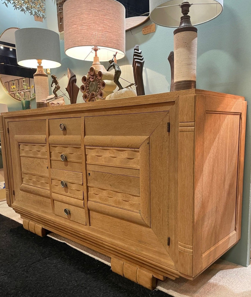 A French 1940s bleached oak sideboard in the style of Charles Dudouyt with two doors and four central drawers and relief front design