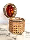 An octagonal rattan jewellery box with brass trim and faux tortoiseshell top in the style of Gabriella Crespi for Dior Home